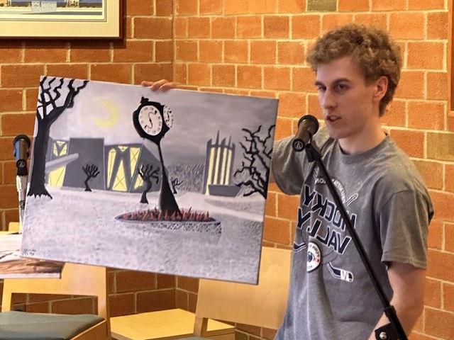Student Talon McKendree displays an original painting of the Penn State 阿尔图纳 campus in the style of German Expressionism.